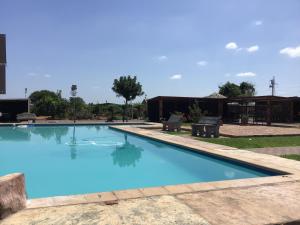 a large swimming pool with blue water in a yard at Tlokweng Rose Garden Guesthouse in Gaborone