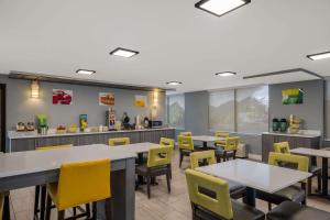 a dining room with tables and yellow chairs at Quality Inn Asheville Airport in Fletcher