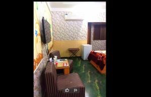Habitación pequeña con cama, mesa y sillas en Prime View Hotel, en Faisalabad