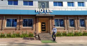 a man is standing in front of a hotel at Prime View Hotel in Faisalabad