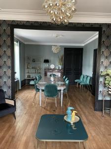 une salle à manger avec une table et des chaises vertes dans l'établissement la maison de Martha, à Jaunay-Clan
