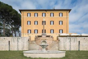 a building with a fountain in front of a wall at Hotel Sacro Cuore in Perugia