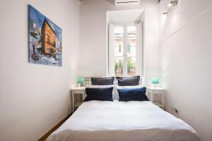 a bedroom with a large white bed with blue pillows at Imperial Loft in Rome