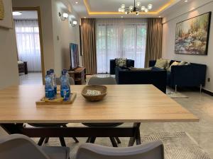 a living room with a wooden table with bottles on it at Diamond Luxury Suite by Diamond Homes in Nairobi