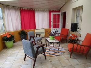 a screened in porch with chairs and a table at suite familiale 2 chambre in Saint-Ouen-les-Vignes