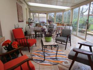 a dining room with tables and chairs and a table with flowers at suite familiale 2 chambre in Saint-Ouen-les-Vignes