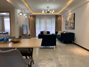 ein Wohnzimmer mit einem Tisch und einem Sofa in der Unterkunft Diamond Luxury Suite by Diamond Homes in Nairobi