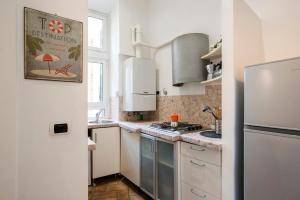 a kitchen with white cabinets and a refrigerator at Imperial Loft in Rome