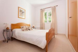 1 dormitorio con cama y ventana en Pinella a lovely 2 Bed Apt. La Sella Golf Urb., en Denia