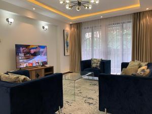 ein Wohnzimmer mit 2 Sofas und einem Flachbild-TV in der Unterkunft Diamond Luxury Suite by Diamond Homes in Nairobi