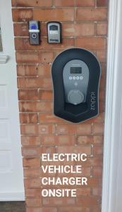 a sign on a brick wall with an electric vehicle charger on it at "Near to the Beach "- 2 bedroom Flat Sleeps up to 5 in Burnham on Sea