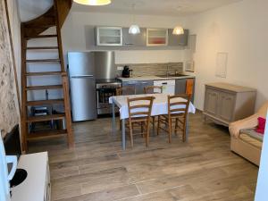 a kitchen and dining room with a table and chairs at Maison en Pierre - Proche de la Mer in Castellare-di-Casinca