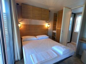 sypialnia z dużym łóżkiem z drewnianym zagłówkiem w obiekcie Camping Villaggio Il Collaccio w mieście Preci