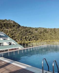 a swimming pool with a mountain in the background at Prince Adriatic Resort in Shëngjin +35 photos