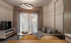 a living room with a couch and a tv at IRIS SUITES NIKITI in Nikiti +43 photos