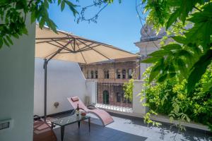 un patio con mesa y sombrilla en Navona Open Space Apartments, en Roma