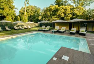 uma piscina com espreguiçadeiras e guarda-sóis em Viktoria Palace Hotel em Veneza-Lido