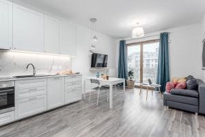 a kitchen and living room with a couch and a table at Chill Apartments Wilanów in Warsaw