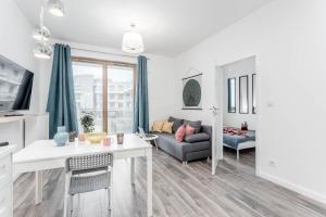 uma sala de estar com um sofá e uma mesa em Chill Apartments Wilanów em Varsóvia