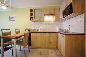 cocina y comedor con mesa y barra en Wonder Home - Apartament Grey w spokojnej okolicy - blisko terenów zielonych, en Karpacz