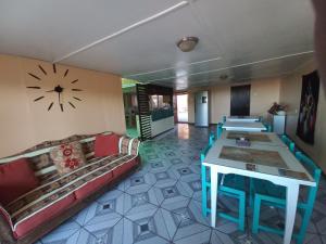 a room with couches and tables and a clock on the wall at Ckoinatur Hostel in San Pedro de Atacama