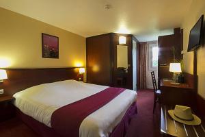 una habitación de hotel con una cama y un sombrero en una mesa en Kyriad Bordeaux Lormont, en Lormont