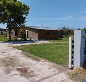 dom z płotem przed budynkiem w obiekcie Cabanon en bord d'estuaire calme en pleine nature w mieście Saint-Yzans-de-Médoc