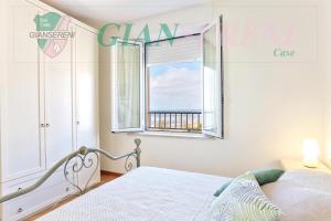 En eller flere senge i et værelse på PIANOSA - Elegante appartamento sul mare