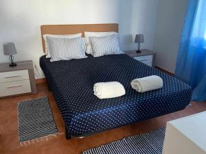 una camera da letto con un letto con due cuscini sopra di Casinha em frente à Lagoa ad Aldeia de Brescos