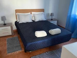 a bedroom with a bed with two pillows on it at Casinha em frente à Lagoa in Aldeia de Brescos