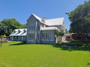 a large house with a lawn in front of it at Woodhills Guest house in Piet Retief