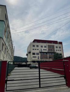 um edifício branco com um portão vermelho e algumas escadas em Citadel Duplex Suites em Sighisoara