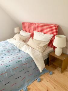 - un lit avec une couverture et des oreillers rouges et blancs dans l'établissement Ferienhaus Feni, à Neckargemünd