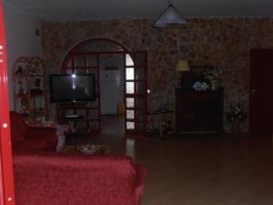 フォンターネ・ビアンケにあるVilla Morrealeのリビングルーム(赤いソファ、テレビ付)