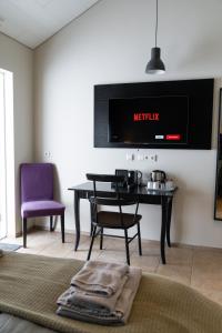 a living room with a table and a tv at HOTEL SNAEFELLSNES formally Hotel Rjukandi in Vegamót