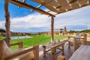 eine Terrasse mit einem Holztisch und Stühlen sowie einem Hof in der Unterkunft Chainteris Villas, a Summer Dream, By ThinkVilla in Prínos