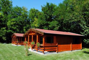 a large wooden cabin with a red roof at Villa Hedi Apartman in Dunakiliti