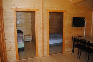 a room with a bed and a television in a cabin at Villa Hedi Vendégház in Dunakiliti