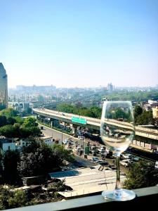 a wine glass sitting on a ledge with a view of a city at Balconies & Venue ( The Grand Anukampa) in Jaipur