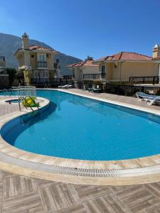 a large swimming pool in front of some buildings at Wonderful Villa In Oludeniz 2 in Kayakoy