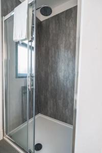 a shower with a glass door in a bathroom at Lakeside Lodge- 'Lapwing' in Bishampton