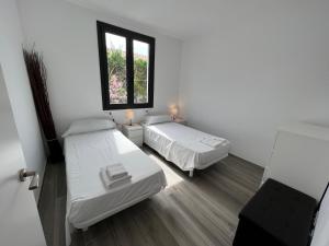 een kamer met 2 bedden en een raam bij MP-Casa Olivera in Torroella de Montgrí