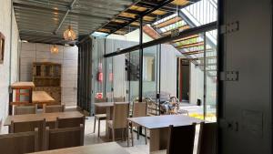 a dining room with tables and chairs and windows at Hospedagem Quinta do Correia in Penha