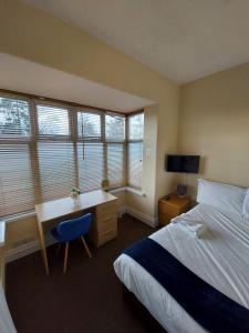 a bedroom with a bed and a desk with a computer at BSL - Filton in Bristol