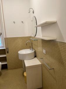 La salle de bains est pourvue d'un lavabo et d'un miroir. dans l'établissement SEABAUDIA1 CON TERRAZZA, à Sabaudia