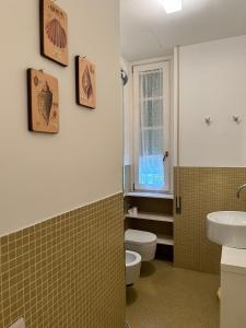 La salle de bains est pourvue d'un lavabo, de toilettes et d'une fenêtre. dans l'établissement SEABAUDIA1 CON TERRAZZA, à Sabaudia
