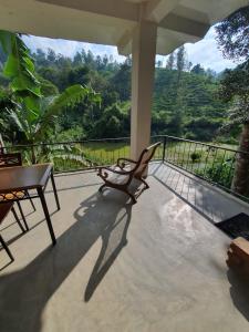 a patio with a table and a chair on a balcony at Ayubo Ella - Bed & Breakfast in Ella