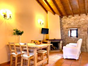 a dining room with a table and chairs and a fireplace at Casal Frias in Barreira
