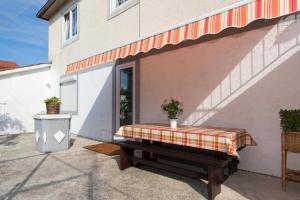 a bench with a blanket on it in front of a building at Apartments Hodanić in Krk