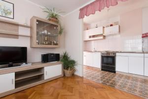 a kitchen with white cabinets and black appliances at Apartments Hodanić in Krk